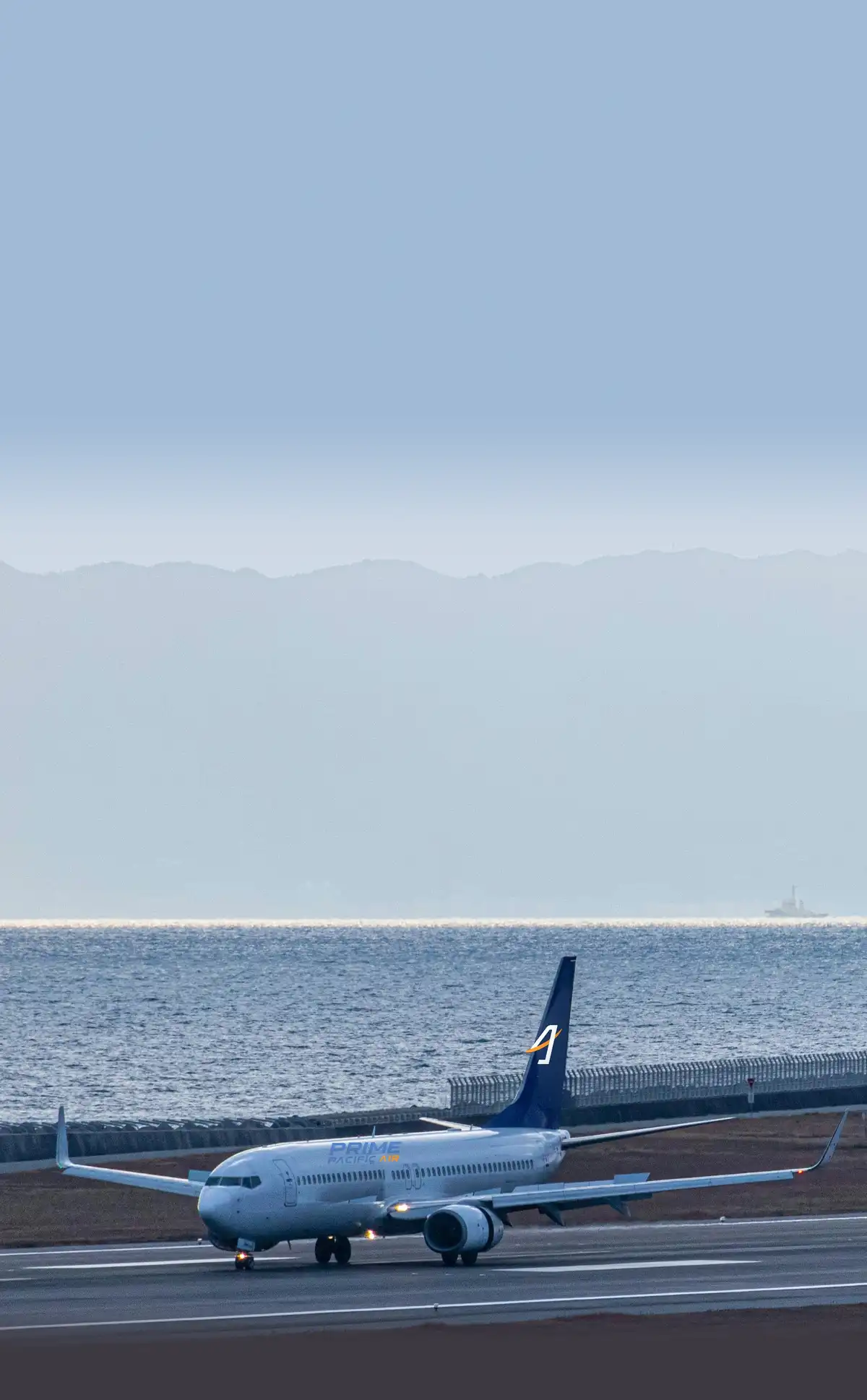 Stock photo of a Boeing 737 on a runway by the sea, with our logo added, not our plane